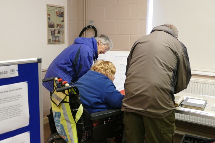 People looking at photos of recent events in the village