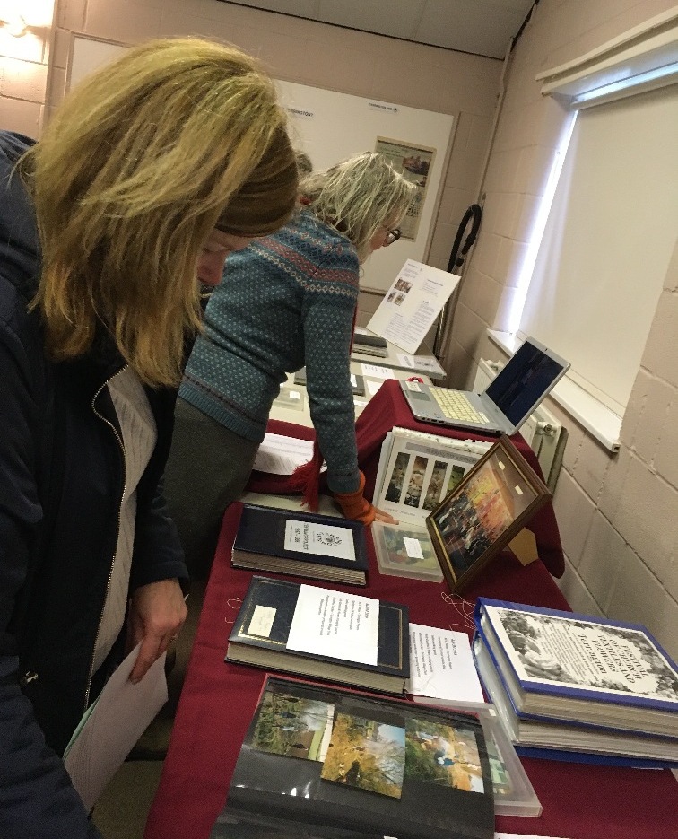 People looking at photos and other information about the village