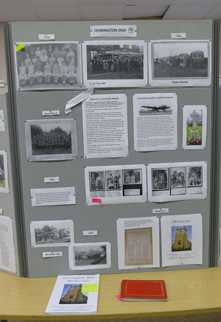 Board with photos of the village in the 1920s, 1930s, and 1940s