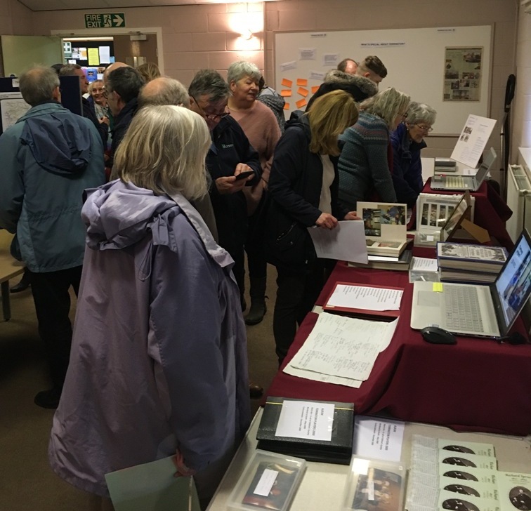 People looking at photos and other information about the village